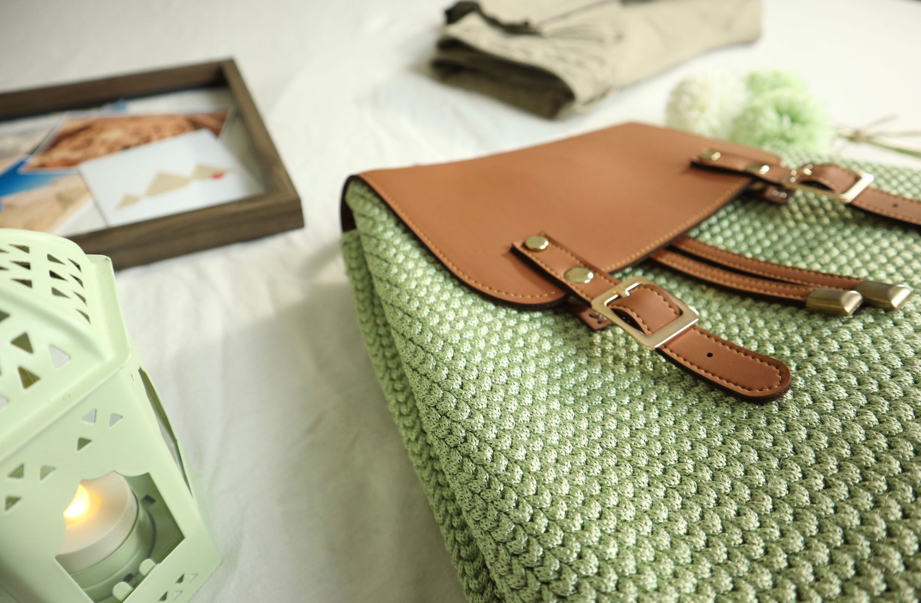 Close-up of a handcrafted crochet bag with leather accents, artistic home decor setting.