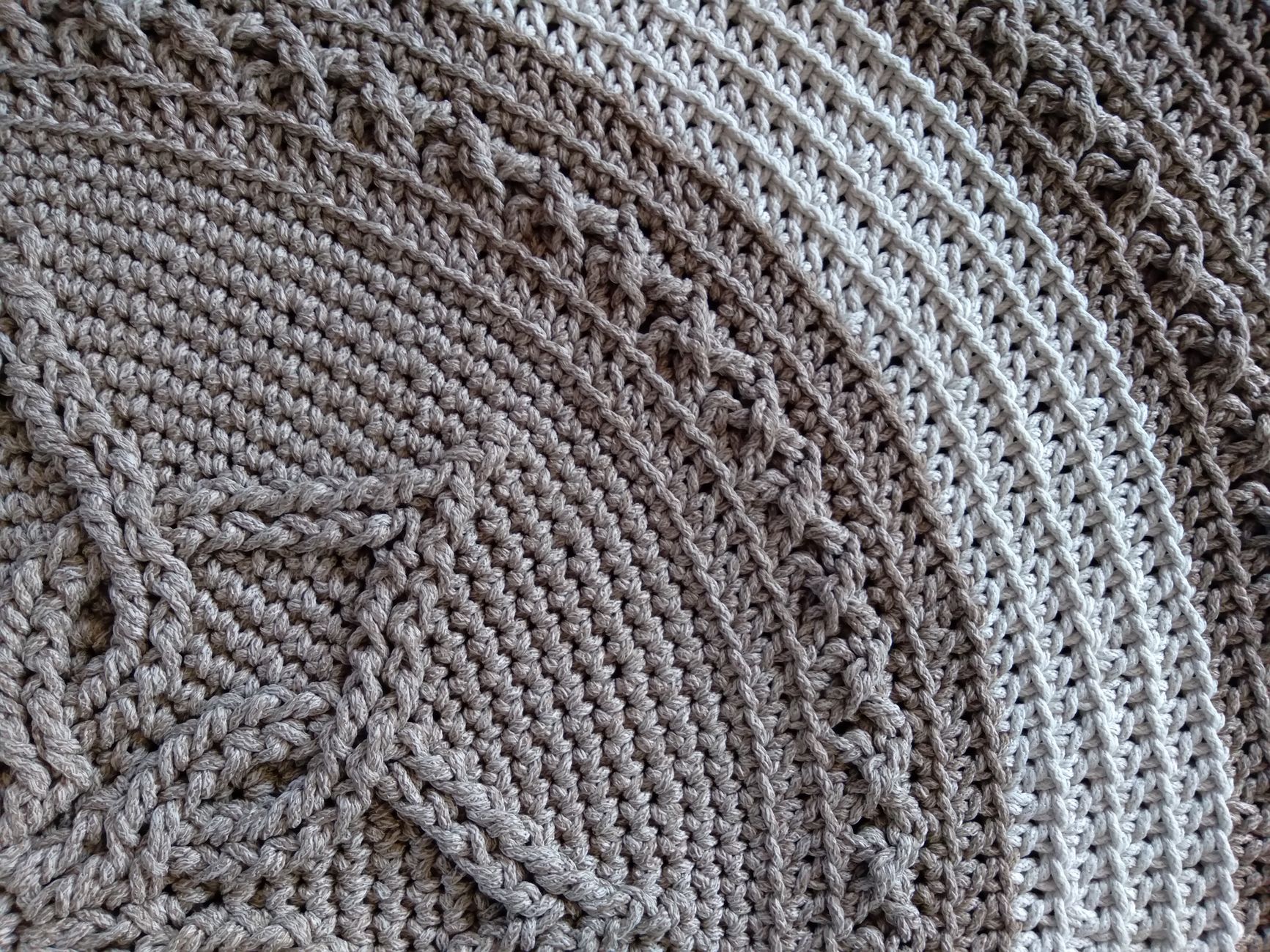Detailed close-up of a handmade crochet texture showcasing intricate patterns in neutral tones.
