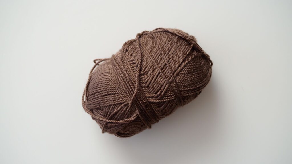 Close-up of a brown yarn ball, perfect for knitting and crafting enthusiasts.