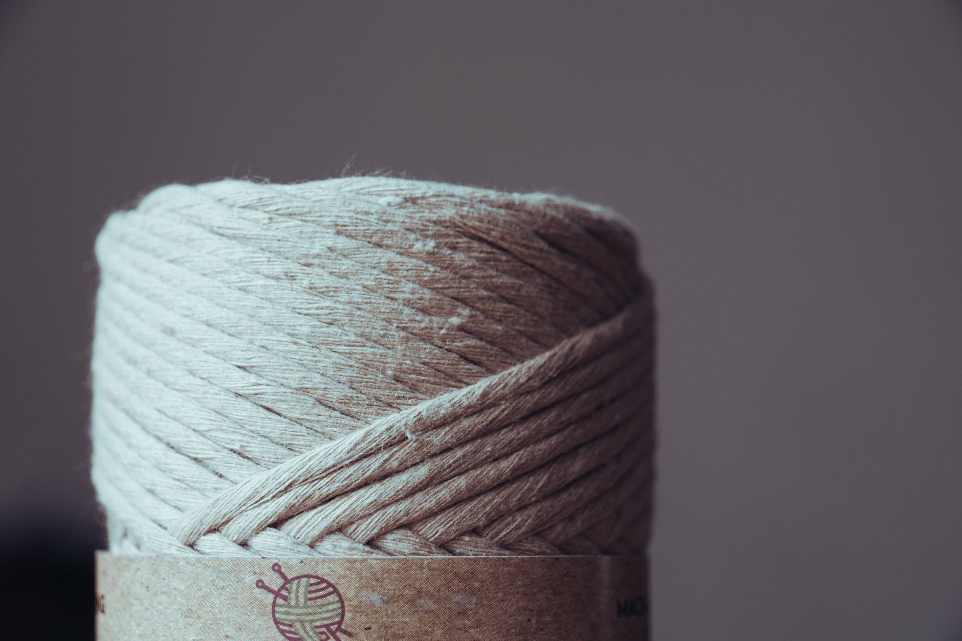 Detailed view of a beige yarn spool, ideal for crafting and needlework projects.