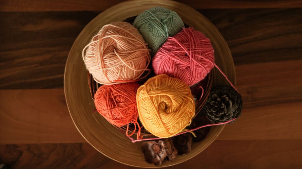 Vibrant yarn balls in a warm setting, perfect for crafting projects.