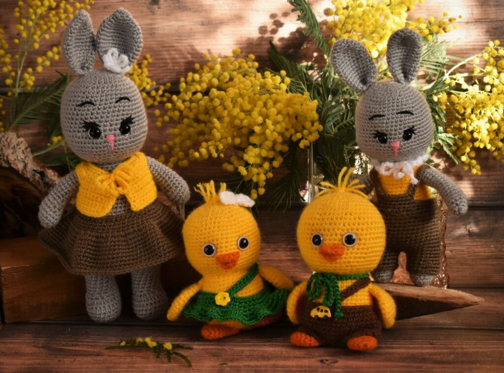 Charming handmade knitted rabbit and duck toys set against a backdrop of vibrant wildflowers.