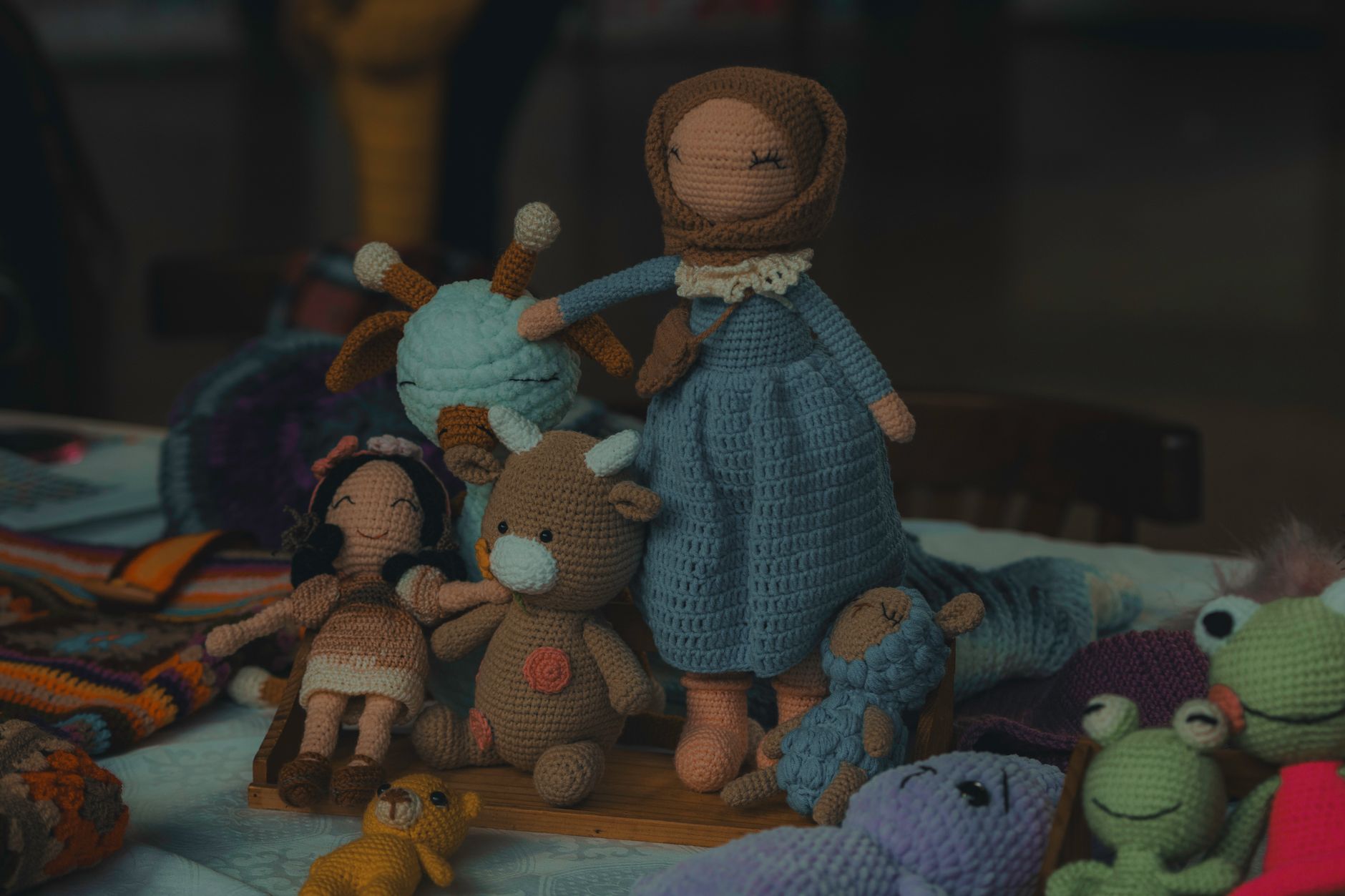 A collection of handmade knitted dolls and stuffed animals, perfect for children.