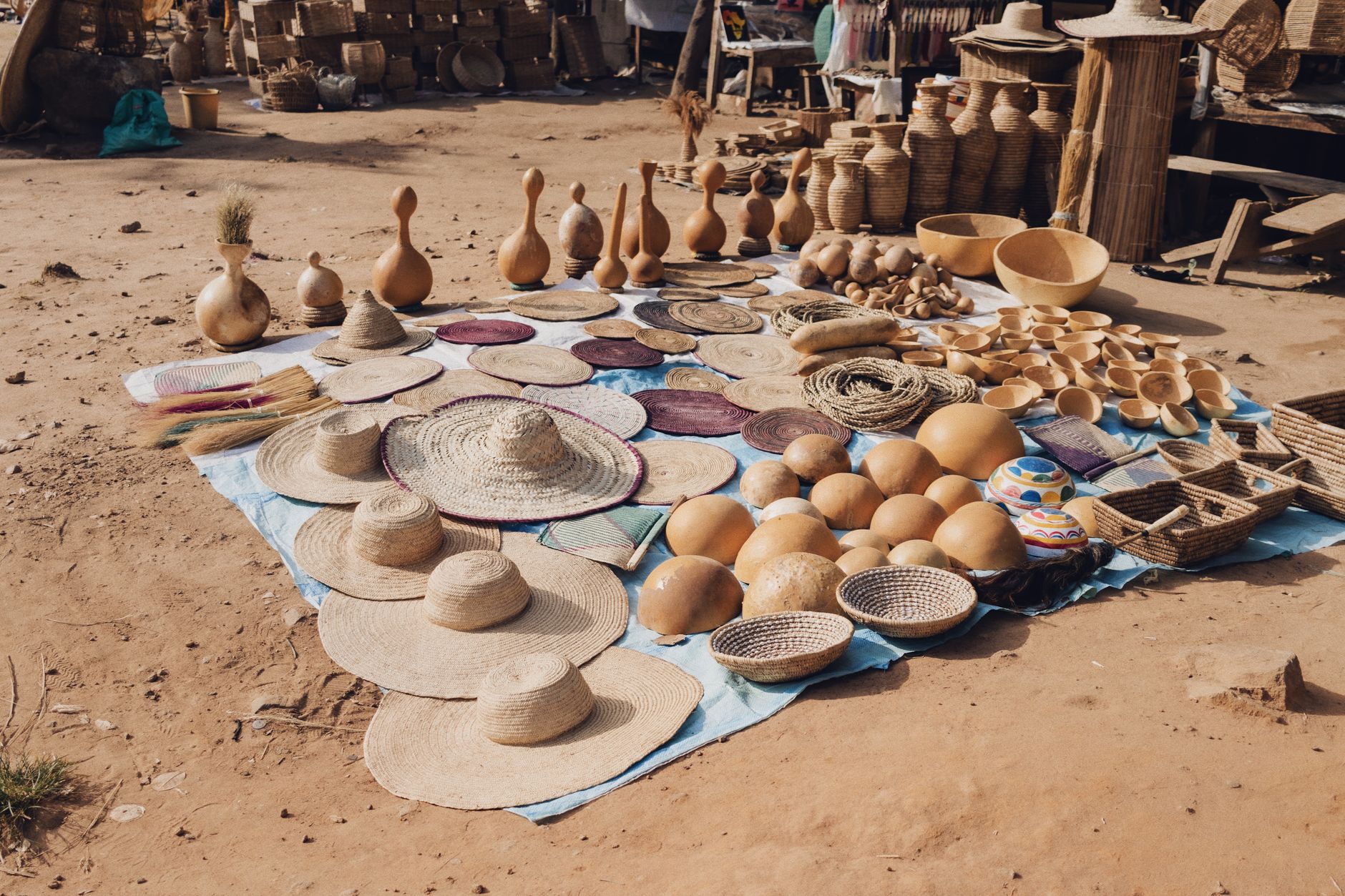 A vibrant display of handcrafted hats and baskets at a local market in Abuja, Nigeria.