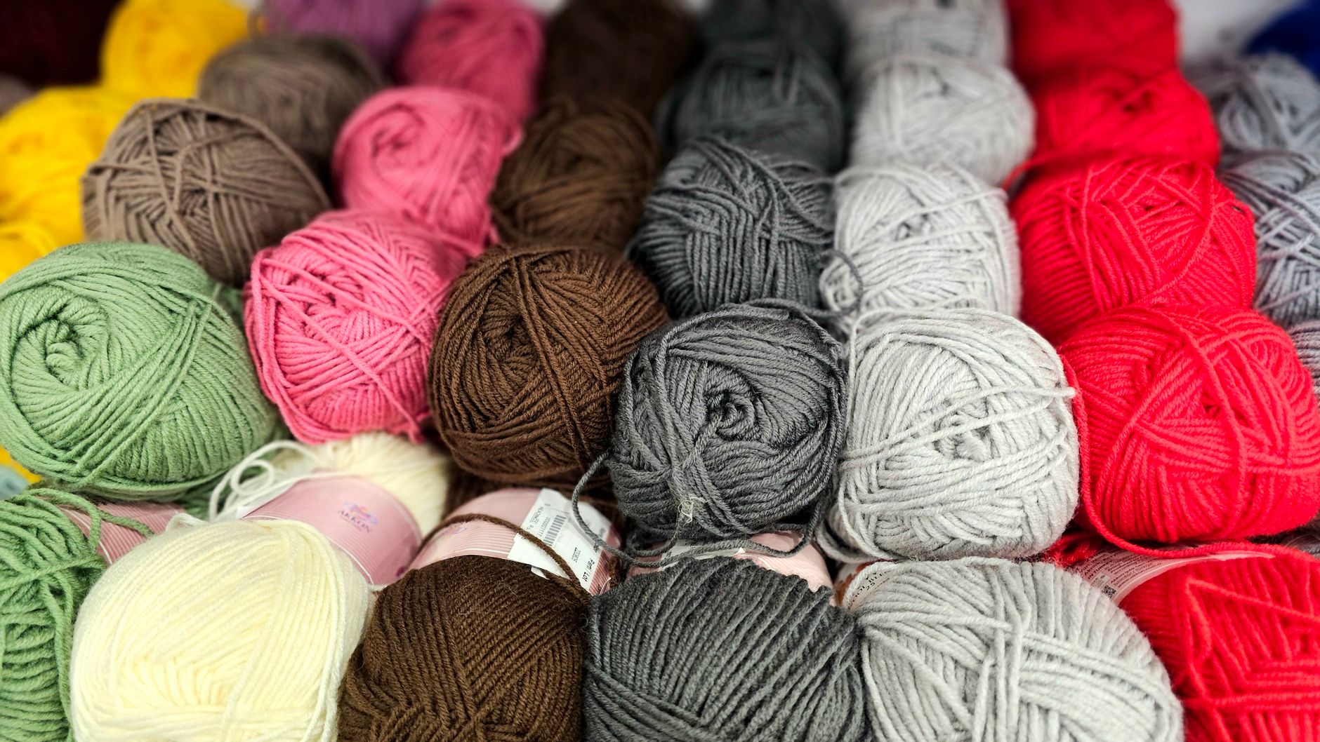 An array of colorful yarn balls perfect for knitting, crochet, and crafting enthusiasts.