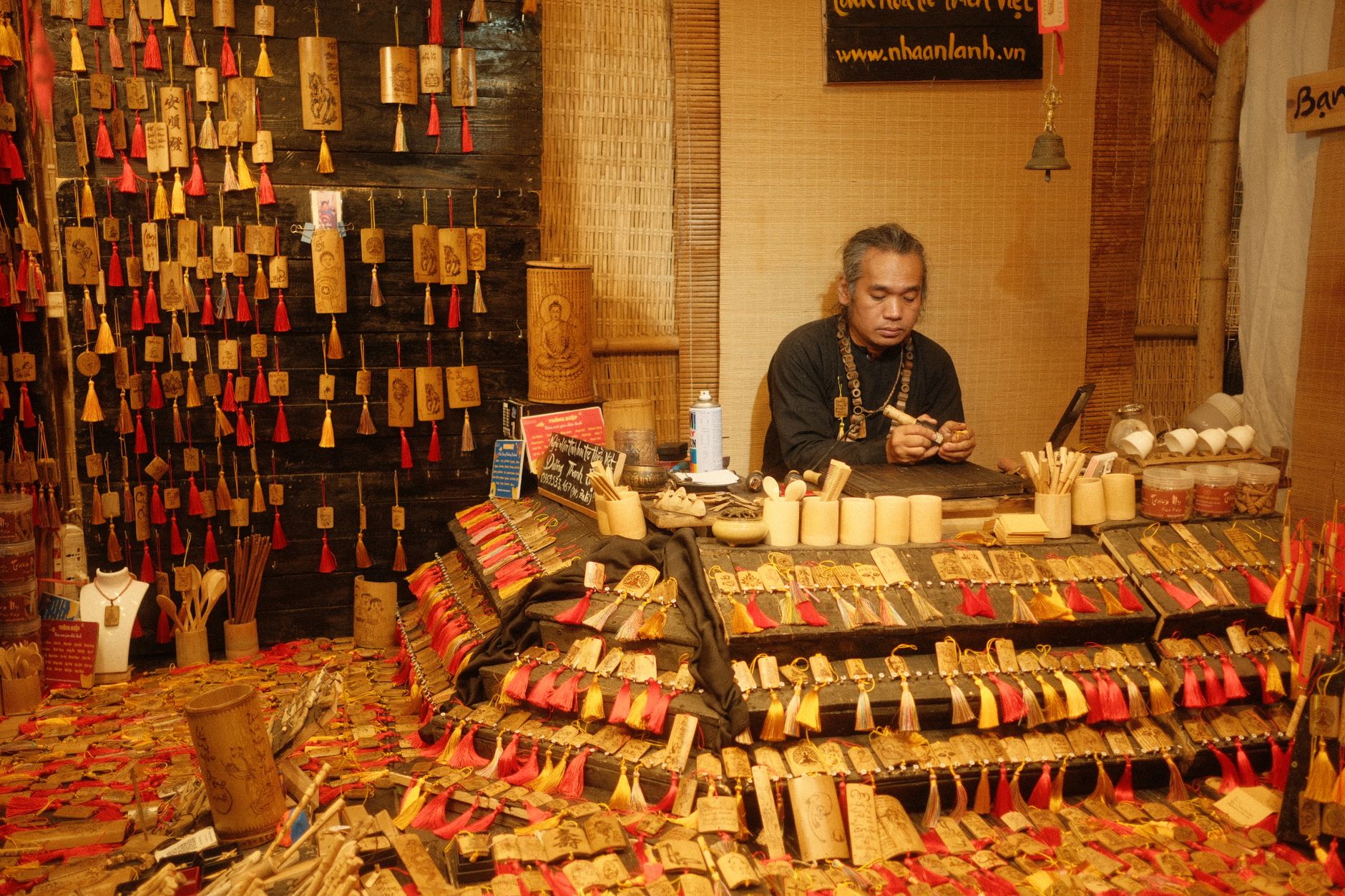 Skilled artisan creating detailed bamboo crafts in a vibrant market setting.