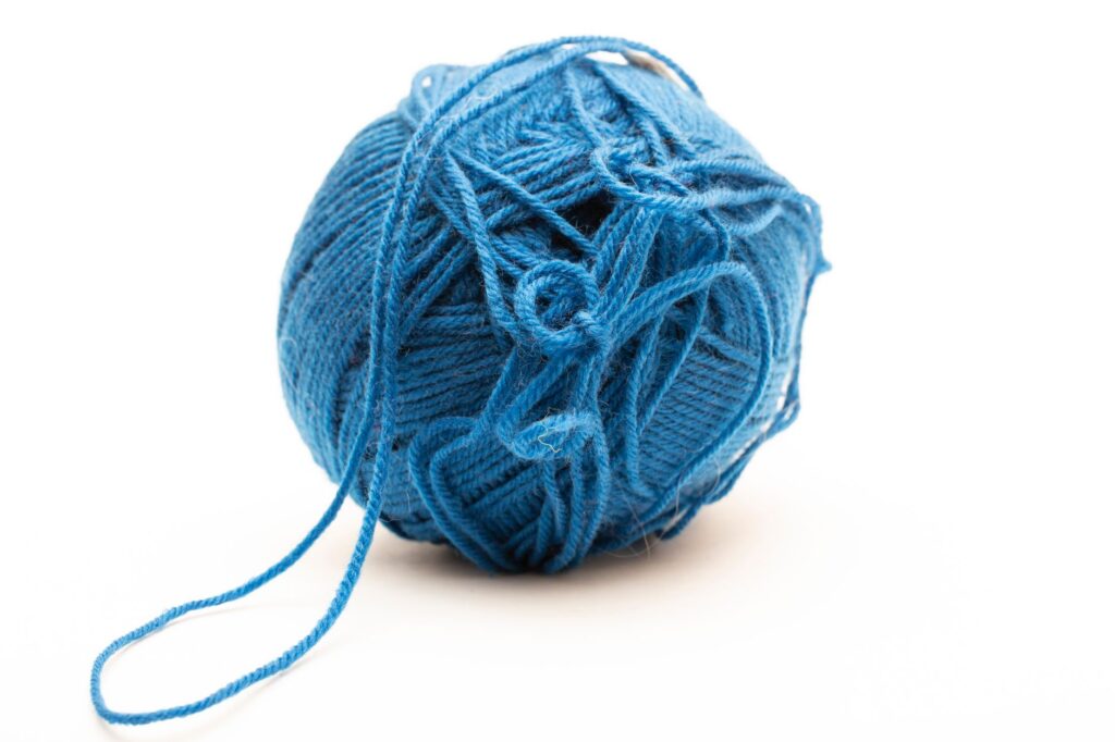 A ball of blue yarn isolated on a white background, perfect for knitting projects.