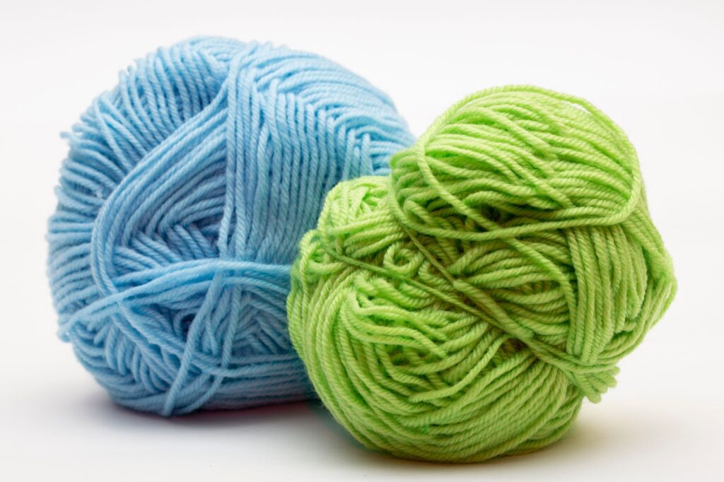 Close-up of soft blue and green yarn balls, perfect for knitting and crochet projects.