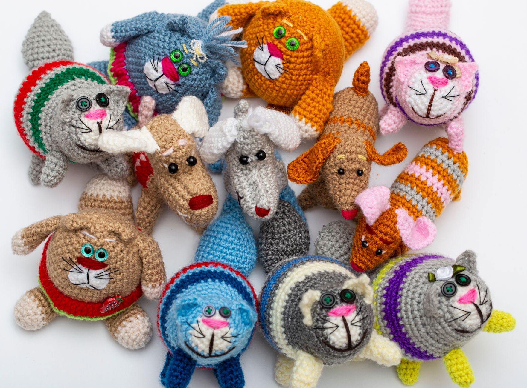 An assortment of colorful crochet animal toys arranged on a white background.