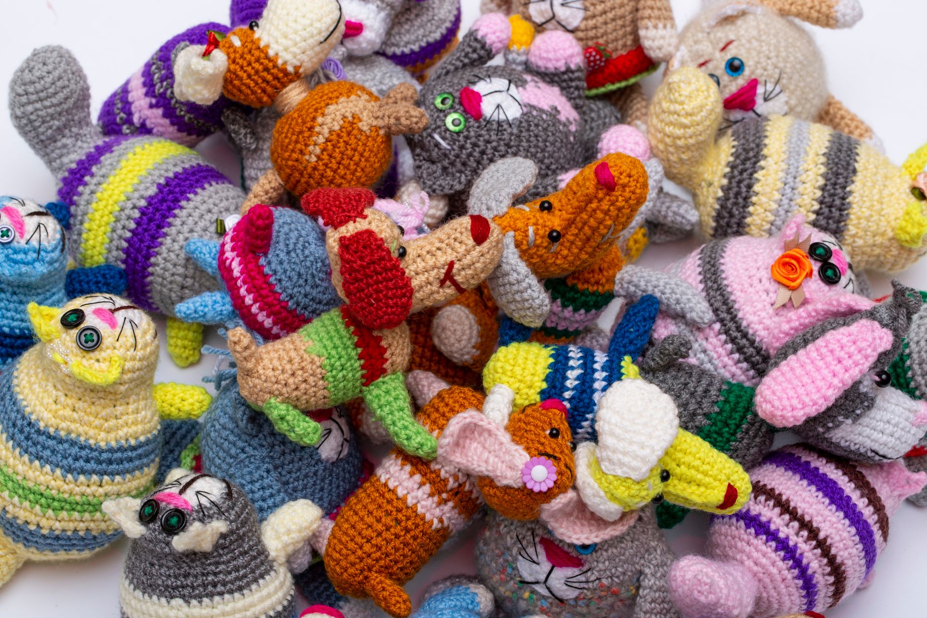 Vibrant knitted animal toys piled together showcasing handmade crocheting detail.
