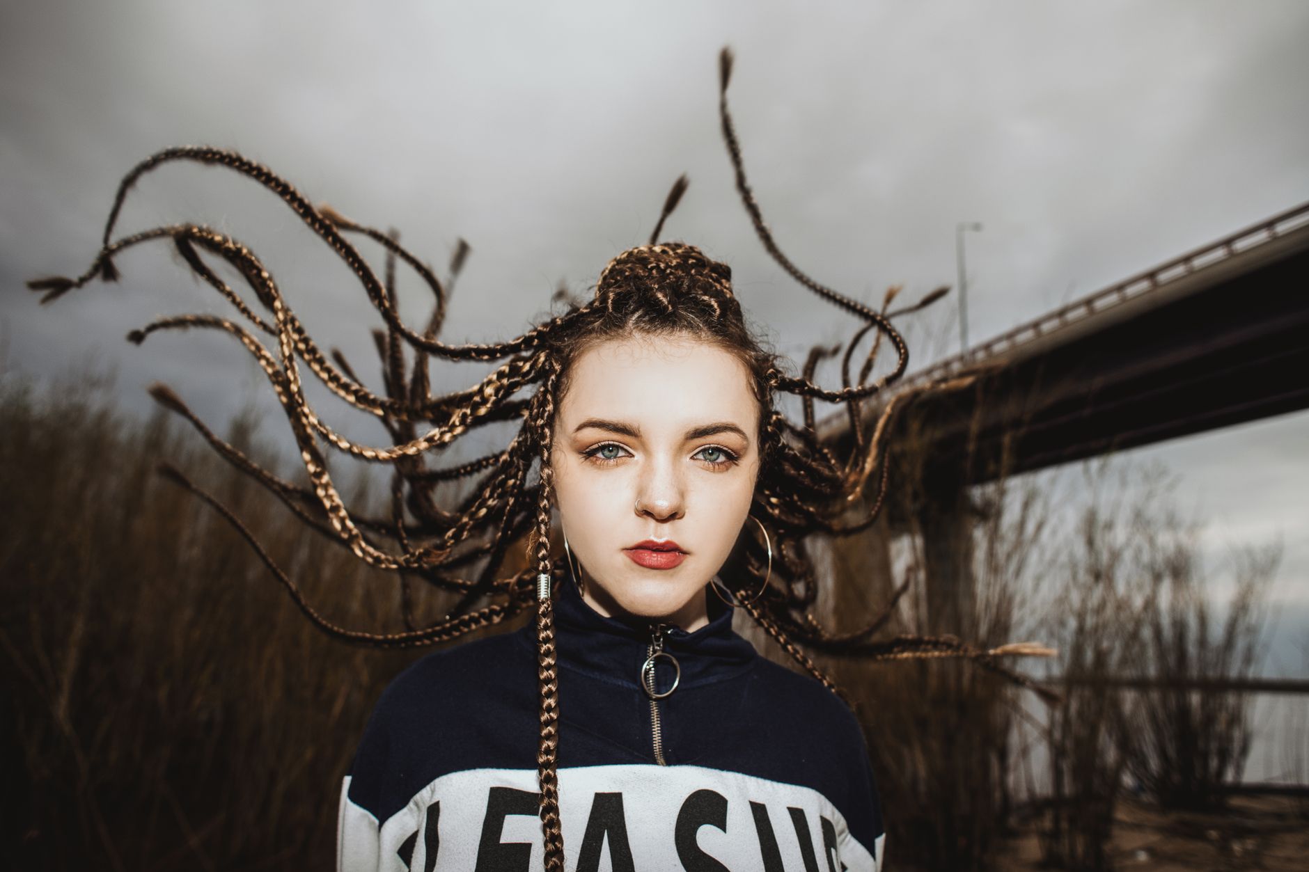 Portrait of a young woman with braided dreadlocks outdoors in an urban area in Russia.