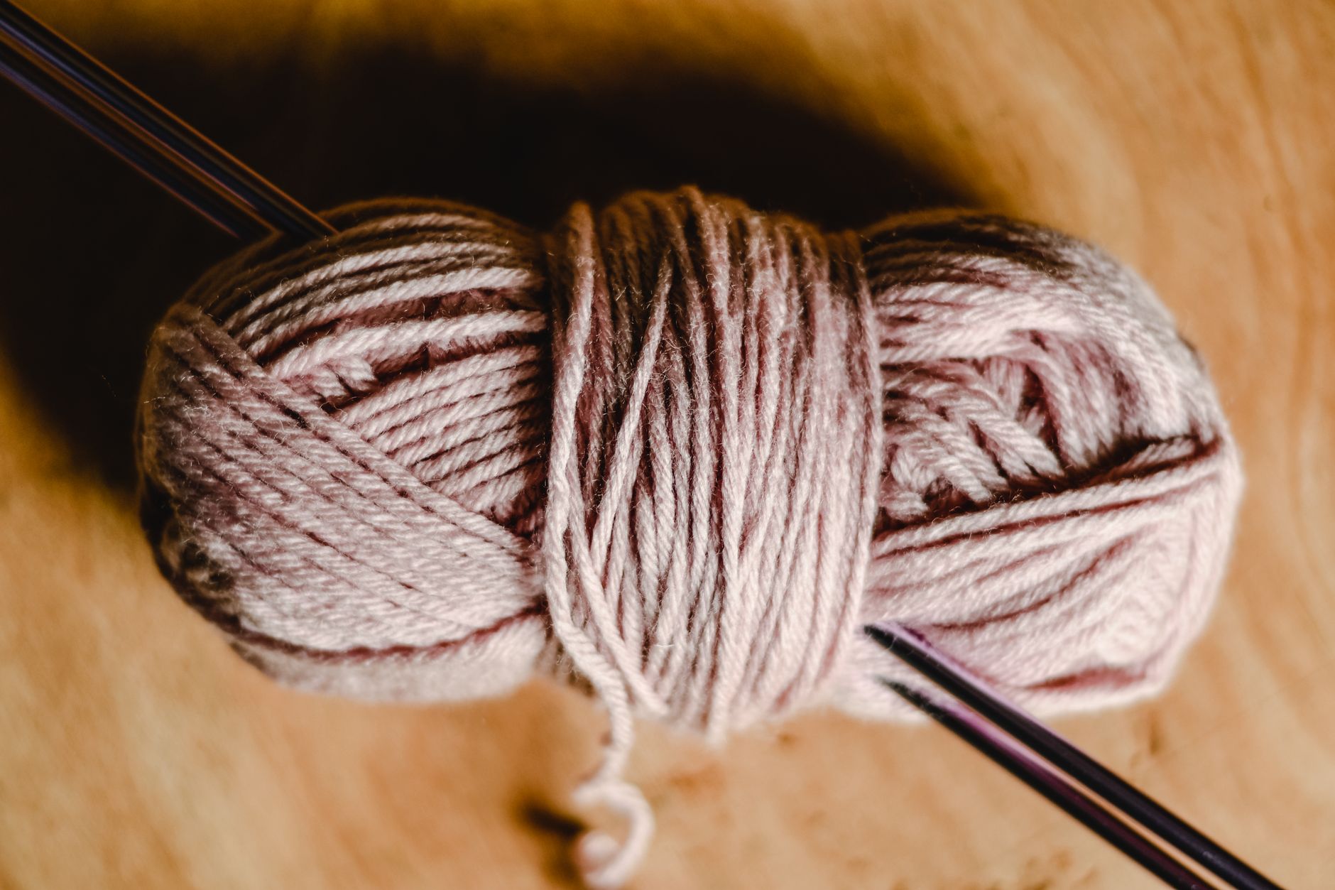 Close-up of a yarn skein with knitting needles, perfect for crafts.