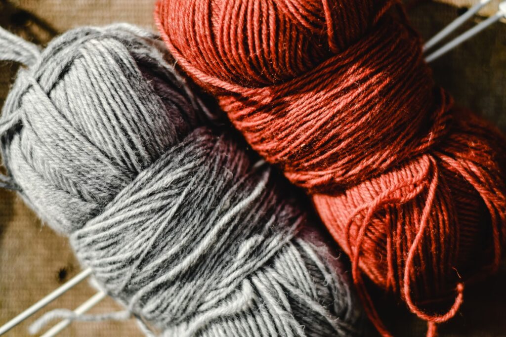 A detailed view of red and gray wool yarn, perfect for knitting projects.