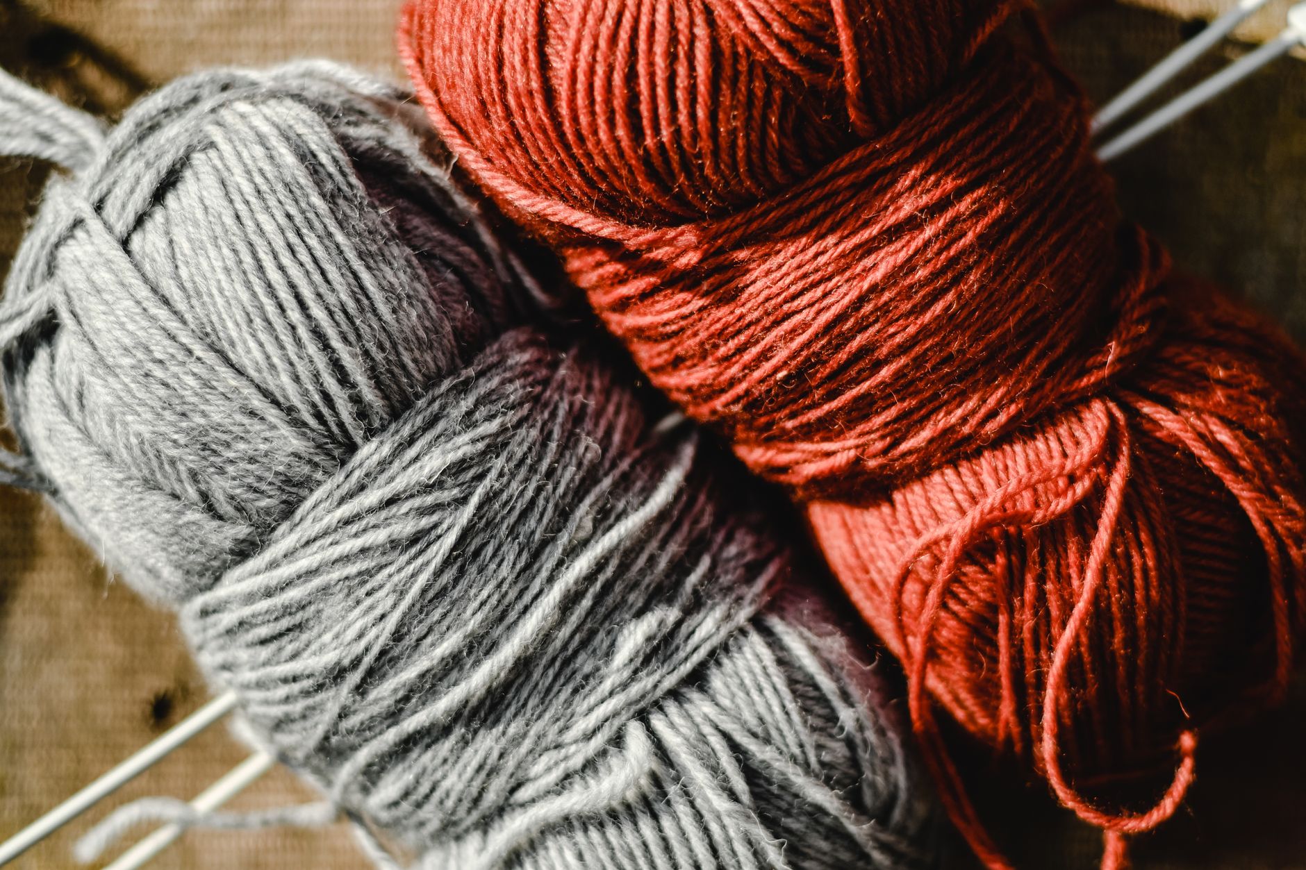 A detailed view of red and gray wool yarn, perfect for knitting projects.