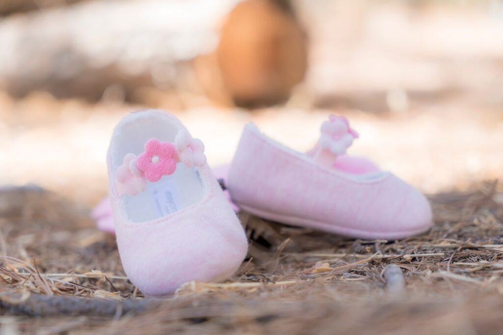Charming pink baby shoes with floral details, perfect for a cute and cozy look.