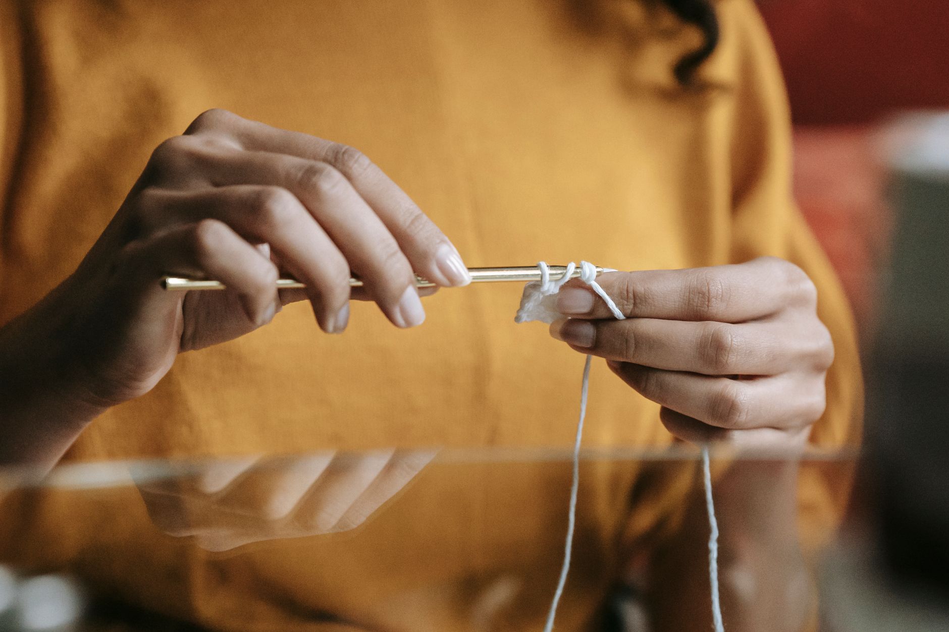 Detailed image of hands crocheting with a crochet hook and yarn, highlighting the crafting process.
